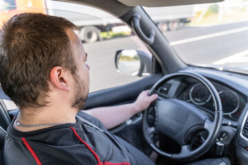 Russian white young man 30-32 years old with a beard from the criminal mafia sits behind the wheel...