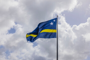 Beautiful view of the Curacao flag waving in the wind against the cloudy sky.