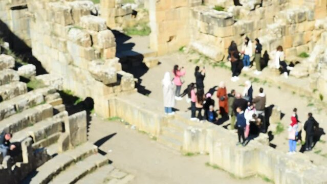 High-angle blurred footage of tourists in the theatre of the ancient Roman town of Djemila. Setif, Algeria. UNESCO World Heritage Site.