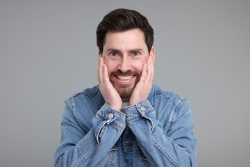 Obraz premium Portrait of happy surprised man on grey background