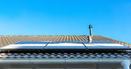 Snow-proof solar panels in icy weather. frost at panel at rooftop. Snow and ice block sunlight and...