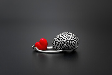 Human Brain with Hands Holds Red Heart on Black