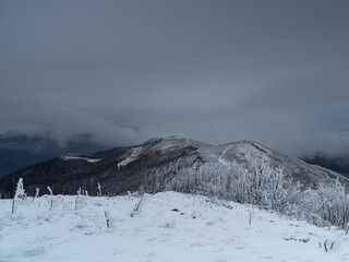 Snow-capped mountain peaks in the fog © Michał Brzostowski 