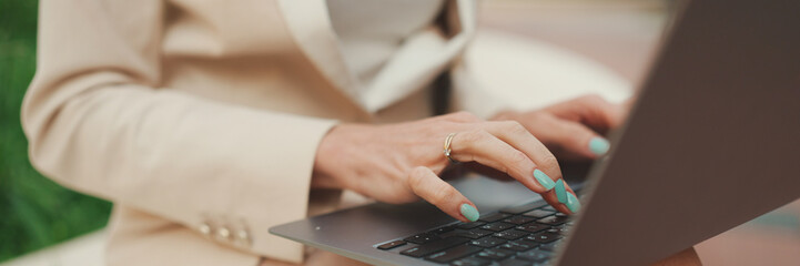 Close-up panorama of female hands working on laptop, pc