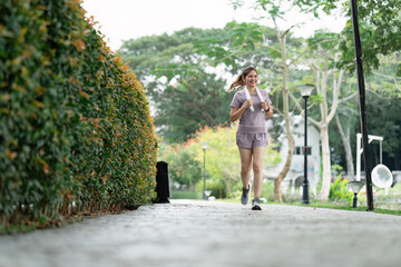 Fototapeta na wymiar Women runner wearing sport cloths jogging in morning at park. Active morning