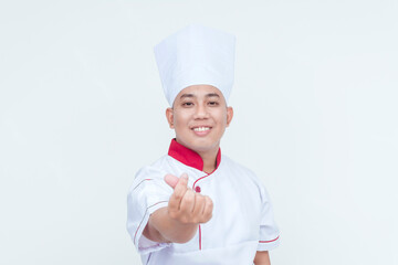 Friendly Asian chef in professional attire making a welcoming finger heart gesture, isolated on a white backdrop.