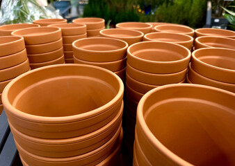 Stacks of terracotta clay pots for plants for sale at a garden store. 
