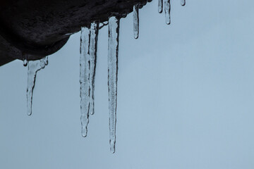 icicles on house roof in cold winter - 722232863