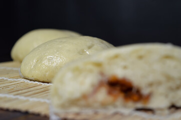 Bapao is a steamed bun with savory or sweet filling. Peanut bakpao  on wooden plate. selected focus.