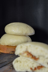 Bapao is a steamed bun with savory or sweet filling. Peanut bakpao  on wooden plate. selected focus.