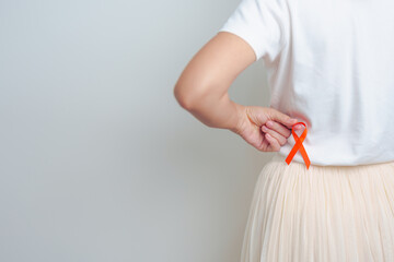 Woman having back abdomen pain with Orange ribbon. Kidney Cancer Awareness March month, disease of Urinary system and Stones, Cancer, Chronic kidney, Urology, Renal and Transplant concept - obrazy, fototapety, plakaty