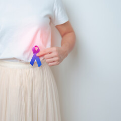 Woman holding Blue ribbon with having Abdomen pain. March Colorectal Cancer Awareness month,...