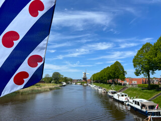 Canal  around the city Dokkum with a frisian flag