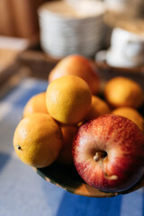 apples and lemons in a bowl on a country table
