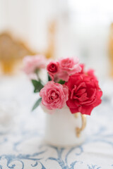 bouquet of pink roses in white vase on a country table