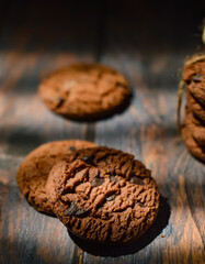 Stack of chocolate cookies on wooden table.