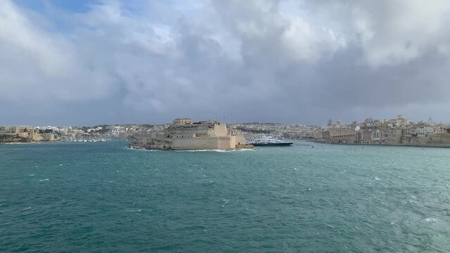Panoramic view of three cities (Birgu (Vittoriosa), Bormla (Conspicua), Senglea) skyline with St. Angelo fort. Motion of heavy Mediterranean sea waves at Grand harbour. View from Valletta, Malta