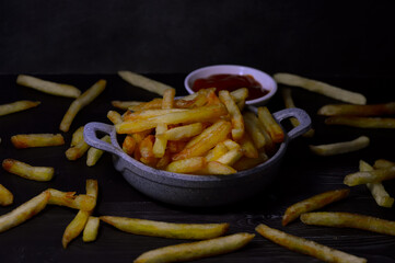 kentang goreng, french fries. Black Wooden background. Focus selective.