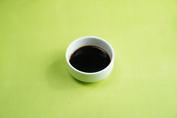 Soy Sauce in bowl on green background