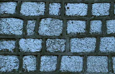 Background, texture of a wall made of natural stone with seams thickly coated with gray cement