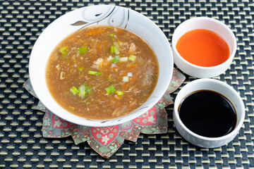 Hot and Sour Soup on textured background
