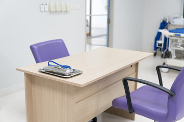 Interior of empty physician office with desk and chairs.Modern and bright doctor office with copy space.Medical tools at doctor working table.
