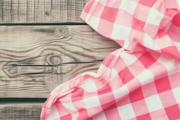 A corner shot of a wooden rustic table partially covered by a draped pink and white checkered tablecloth, which evokes a sense of home, comfort, and the beginning of a family meal. The texture of the