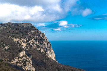 Fototapeta na wymiar high mountains against a blue sky and sea background