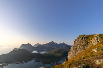 Soft sunlight of the midnight sun graces the peaks and cliffs near Nappstraumen in the Lofoten...