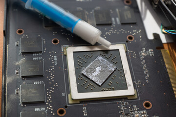 the process of applying thermal paste to the processor, which is located on the motherboard. Remnants of old thermal paste are visible on the processor