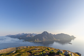 The midnight sun bathes the Lofoten Islands in a warm light, with the view from Offersoykammen...