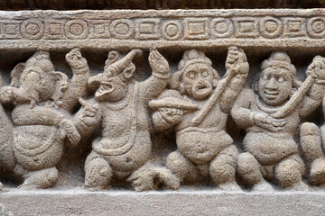 Carving of Dwarf-like Yakshas in Temple. Sandstone relief carving of ancient mythological sculptures on the wall of historic Kailasanathar temple in Kanchipuram.