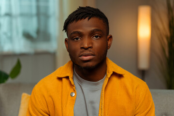 Portrait of pensive young African American man wearing casual clothes looking at camera