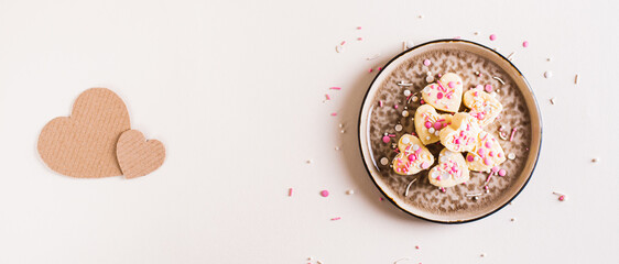 Homemade white chocolate candy hearts with icing on a plate on the table top view web banner