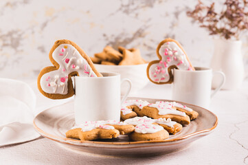 Homemade cookies hugging a coffee mug on a plate on the table