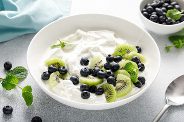 White plain greek yogurt with fresh blueberries and kiwi fruit