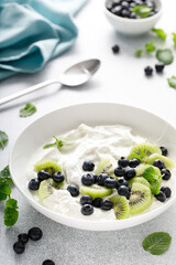 White plain greek yogurt with fresh blueberries and kiwi fruit