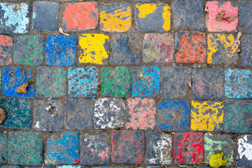 Photo of a vibrant street art piece featuring painted cobblestones in an array of colors, offering a playful twist on urban surfaces.