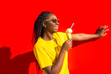 Happy young african woman eating an ice cream