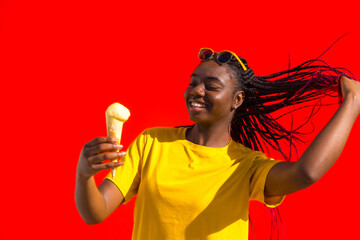 Playful african young woman holding an ice cream