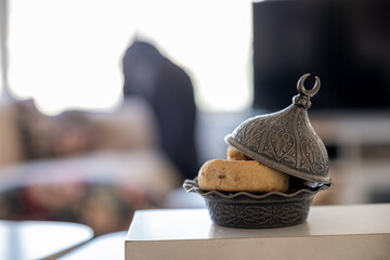 Eid sweets on white table with home decorations in the background
