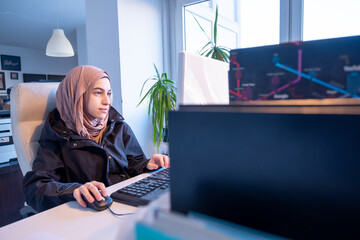 Muslim female working in office using computer with white background, represent power of arabian...
