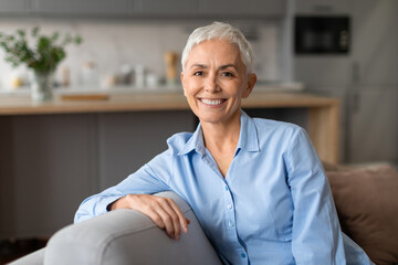 caucasian senior woman posing on couch expressing positivity at home