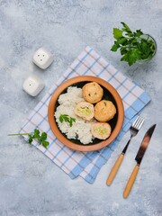 Step-by-step cooking of meatballs stuffed with feta and pesto sauce. Step six, meatballs stuffed with feta cheese and garnished with rice in a ceramic bowl. Step-by-step recipes.