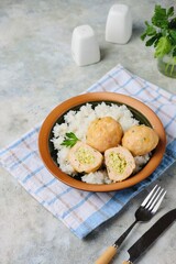 Step-by-step cooking of meatballs stuffed with feta and pesto sauce. Step six, meatballs stuffed with feta cheese and garnished with rice in a ceramic bowl. Step-by-step recipes. Minced meat recipes