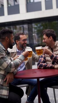 Best friends togehter, drinking beer and talking in bar in city. Concept of male friendship, bromance.