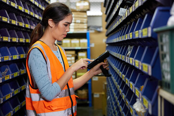 factory worker using laser barcode scanner and looking spare parts storage cabinet