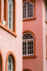 Peach colored vintage building detail exterior with arched windows and doors in the color of peach fuzz.