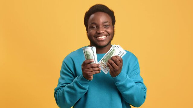 Portrait of happy African American young man counting money and good salary or success in business