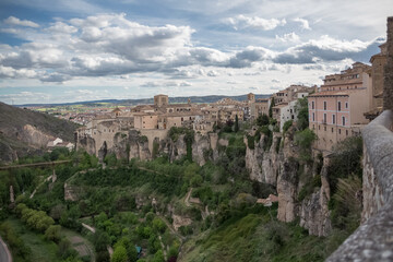Cuenca Spain - 05 13 2021: View at the Cuenca Hanging Houses, Casas Colgadas, Church of San Pedro and other buildings on the edge at the cliffs, on city touristic downtown, Cuenca downtown, Spain